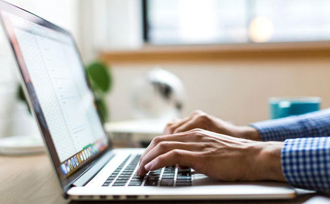 A man using a laptop to research and select the ideal texting software for his nonprofit organization.